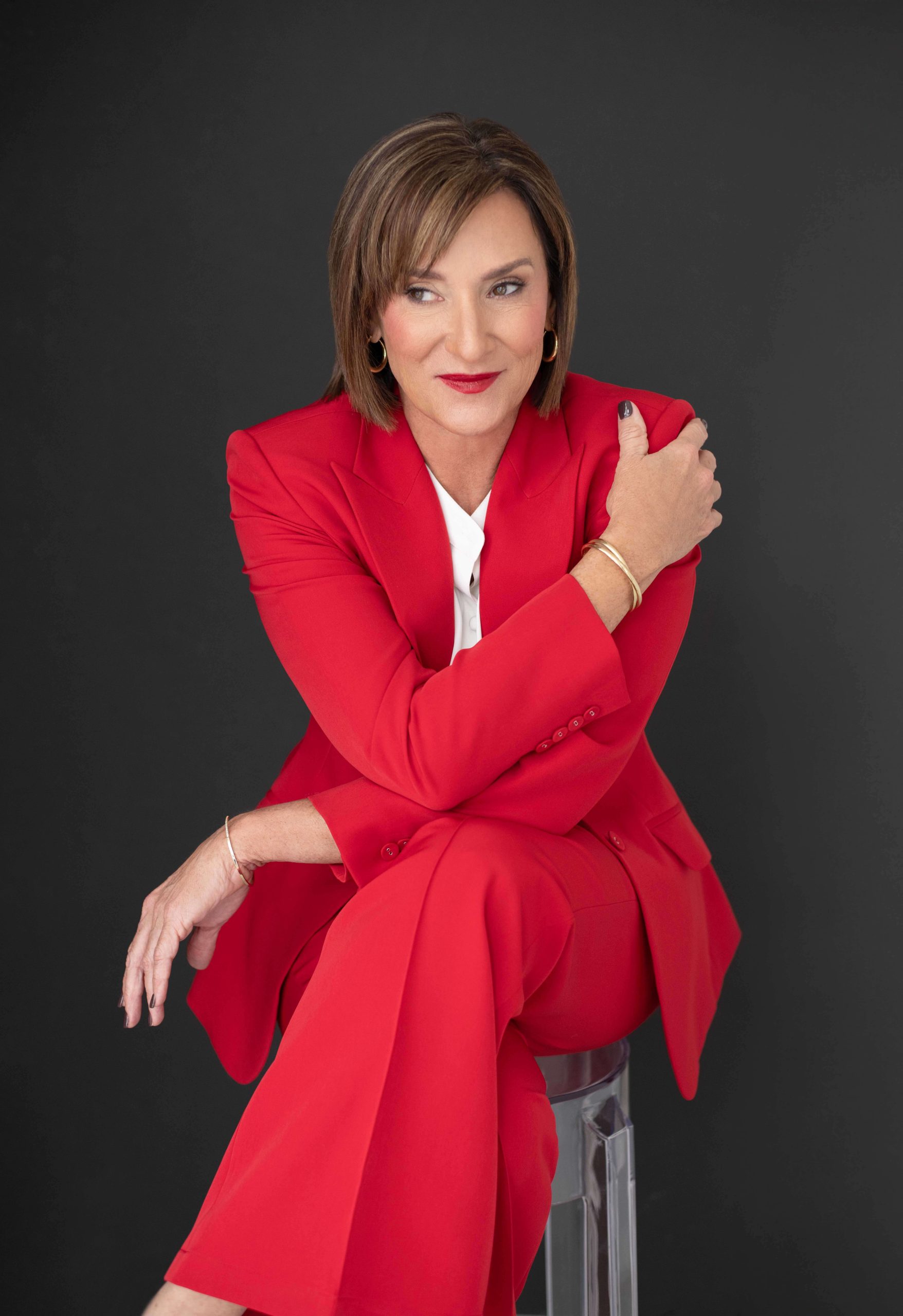 Lori S. Murray sitting on chair in suit looking at camera